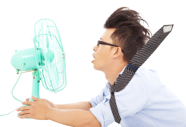 man standing close to fan to stay cool