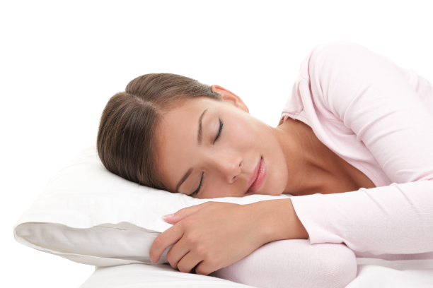 Woman in pink pajamas sleeping soundly on white bedding with eyes closed and relaxed expression.